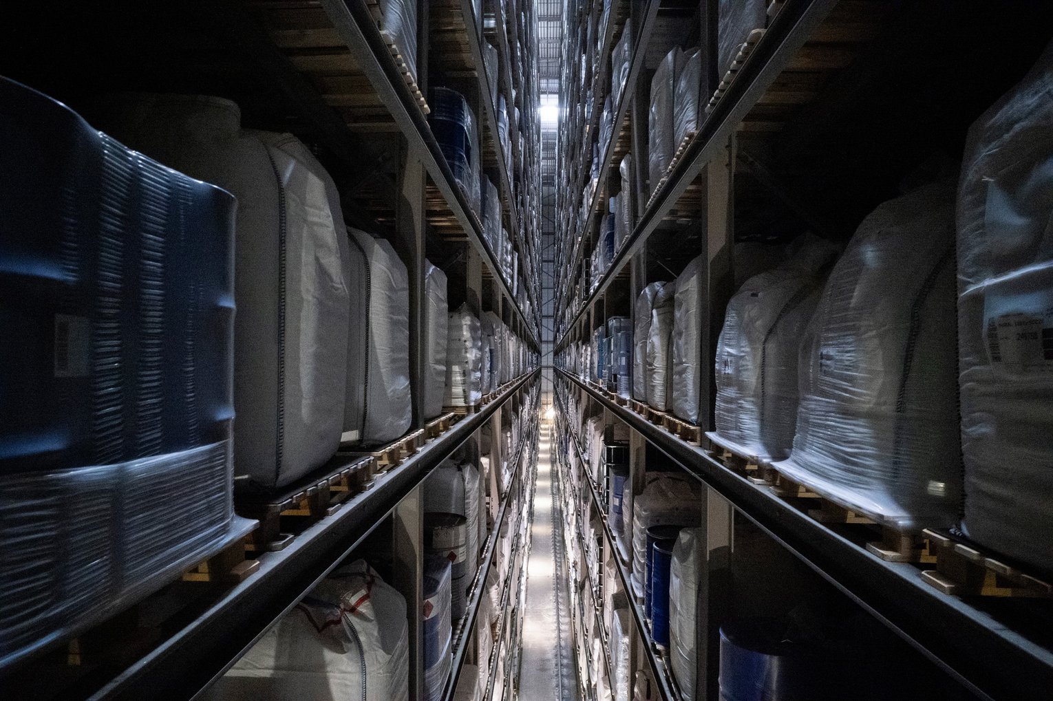 Innenansicht eines Hochregallagers Blick in ein hohes, automatisiertes Hochregallager mit schmalen Gängen und Paletten.