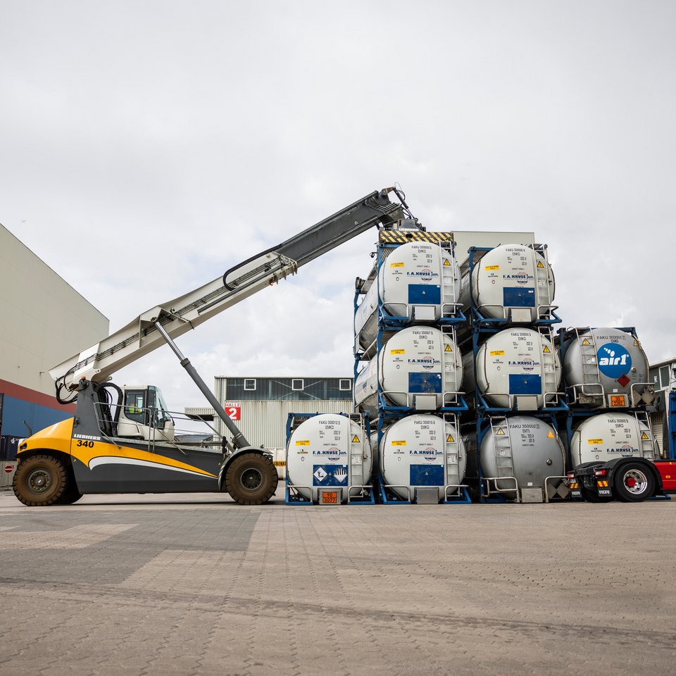 Containerumschlag mit Kruse-Lkw auf dem Hof Ein Kran verlädt Gastanks auf dem Firmengelände von Spedition Kruse