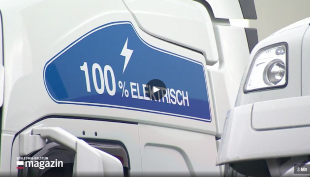 Elektrischer LKW im Detail Nahaufnahme eines weißen LKW mit blauem Schriftzug „100% elektrisch“.