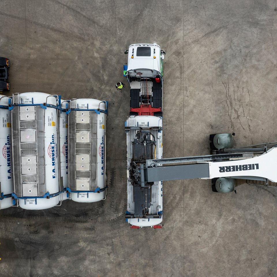 Containerverladung mit Stapler und Lkw aus der Luft Draufsicht auf einen Containerstapler, der Tankcontainer auf einen Lkw verlädt, daneben mehrere abgestellte Container.