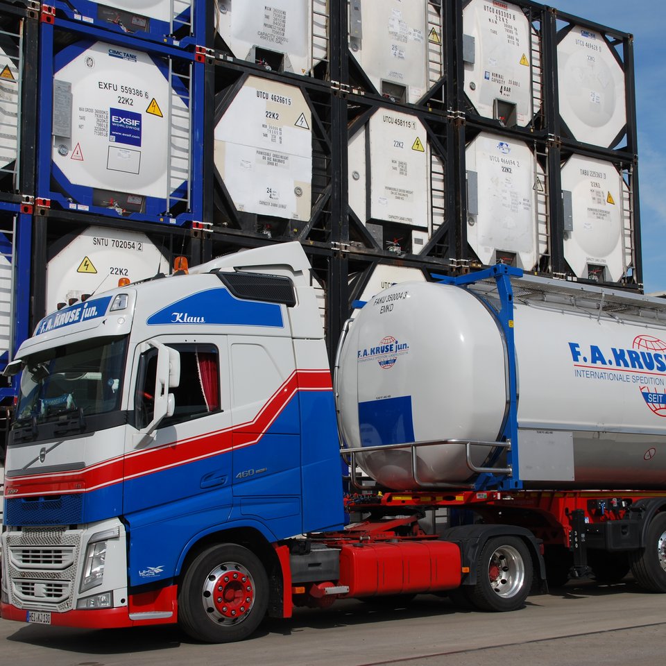 Kruse-Lkw mit Tankcontainer vor Containerlager Lkw der Spedition Kruse mit Tankcontainer, im Hintergrund gestapelte Container mit Kruse-Logo