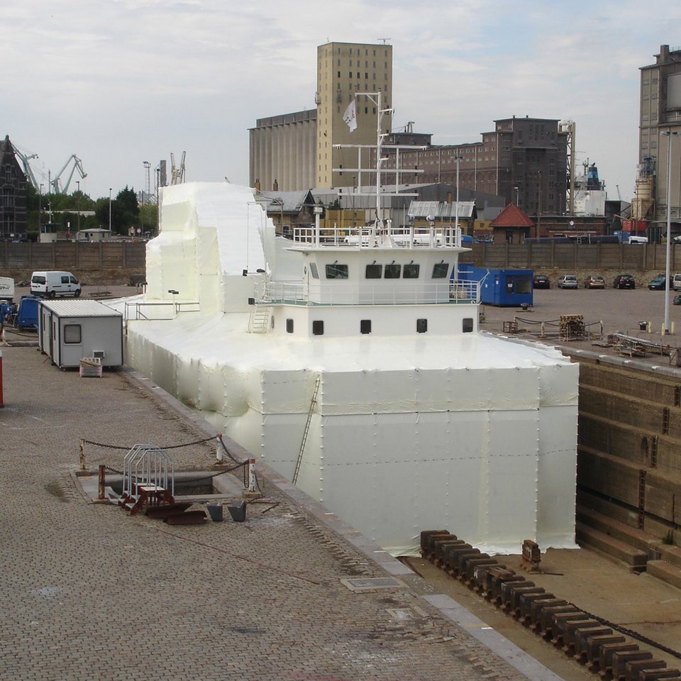 Schiff im Trockendock vollständig in weißer Folie eingepackt